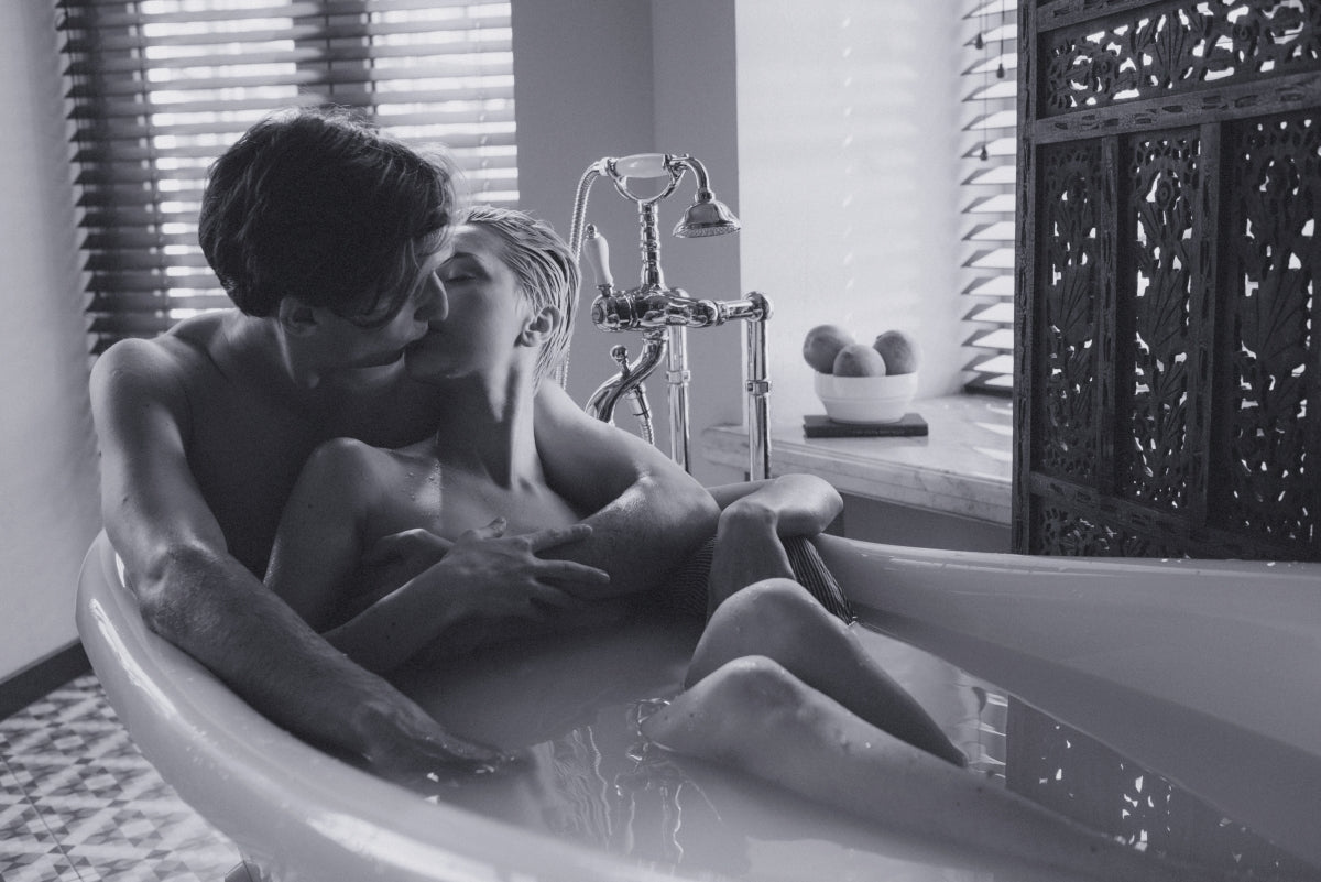 A sexy couple soaking in the tub together and kissing each other